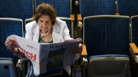 Helen Thomas reads the newspaper while sitting in her chair in the White House press room in 2006. She died on Saturday at age 92.