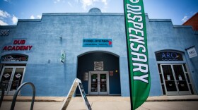 A blue building with a green vertical banner that reads "dispensary."