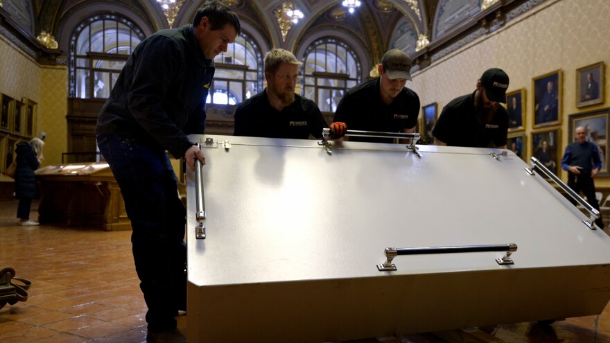 The team from FIRELOCK lifts the charter’s vault. It is typically stored flat, but needed to be turned on its side to navigate the hallways of the State Library.