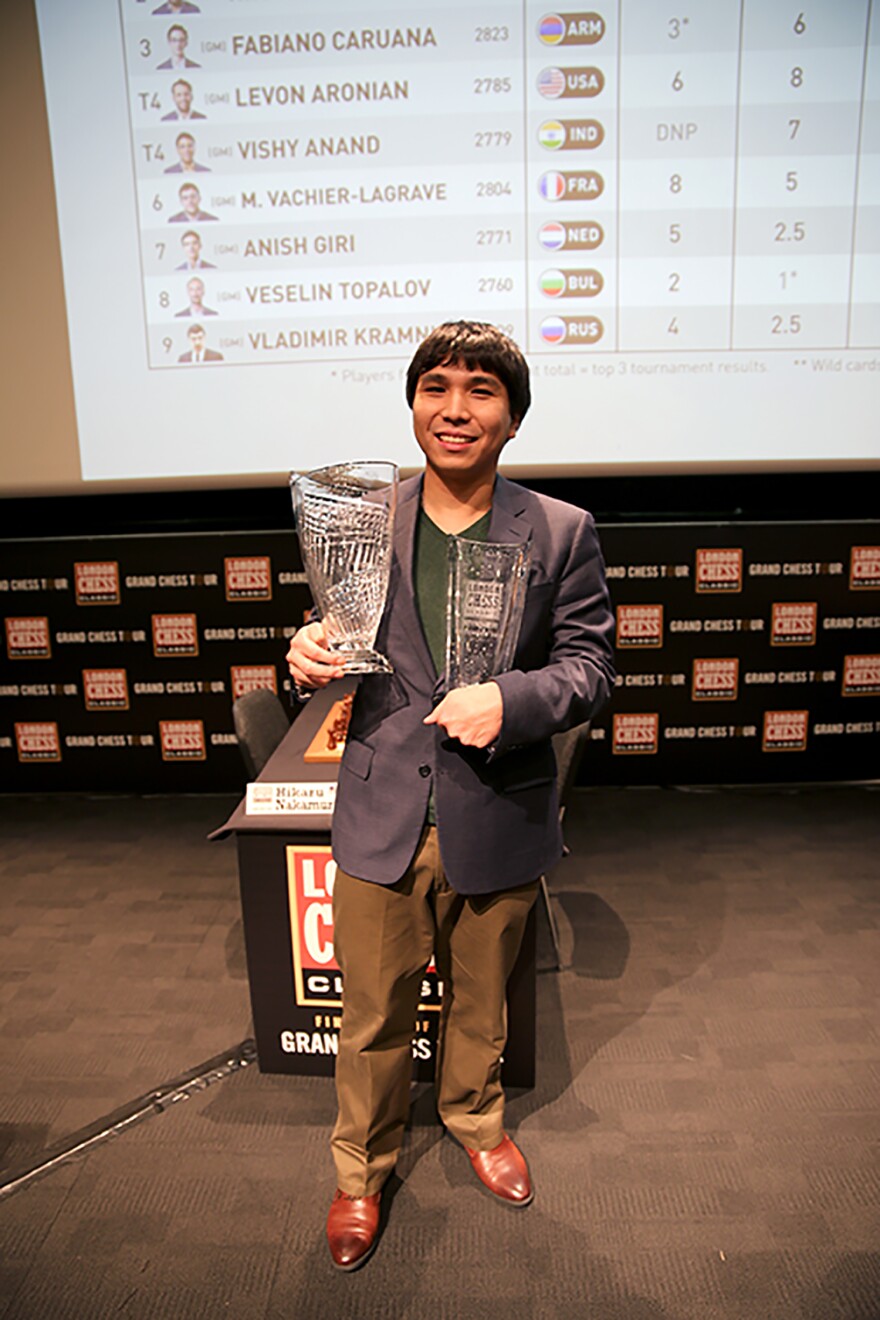 Wesley So holding chess trophies