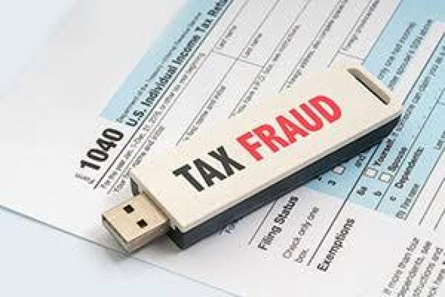 USB drive saying "tax fraud" on top of 1040 tax form