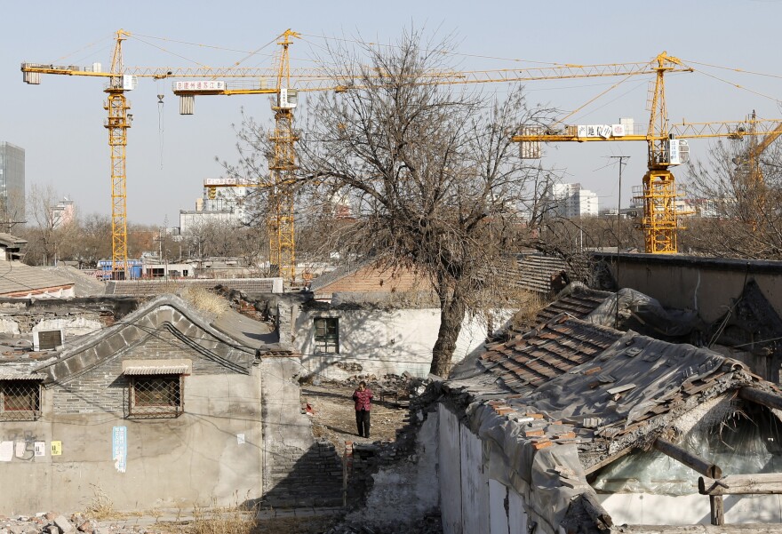 A woman in Beijing stands amid houses being demolished for new residential town, on Feb. 27.
