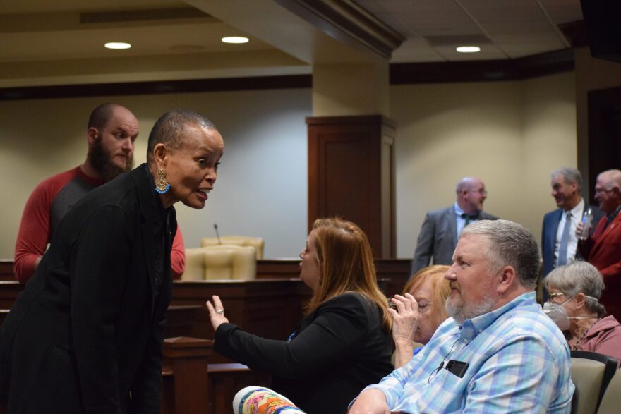 Joyce Elliott, a former state senator and teacher, speaks with a member of the public prior to testifying during a House committee meeting Tuesday.