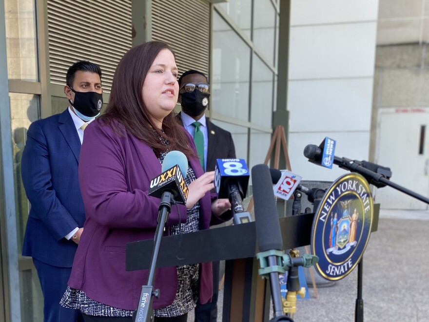 Assemblymember Jen Lunsford speaks at a podium to announce $3.5 million legal defense fund.