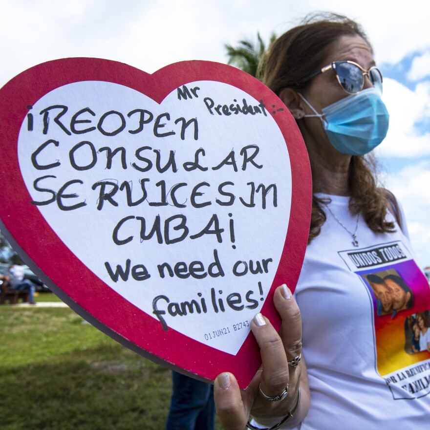 Marietta Medialdea holds a heart-shaped candy box with a message to President Biden to restart consular services in Cuba.