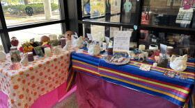 An ofrenda to honor pets, featuring photos, candles, flowers, treats, toys, and animal-shaped candy skulls.