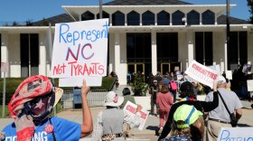 FILE - Demonstrators approach the Legislative Building during a rally protesting a proposed election redistricting map, Oct. 21, 2025, in Raleigh, N.C.