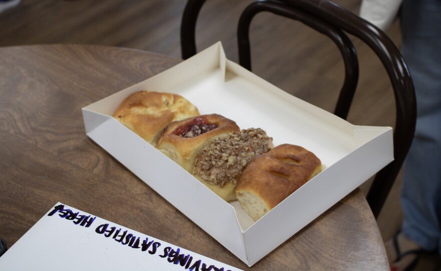 A box of pastries sits on a table inside the Village Bakery during their reopening on Saturday, May 23, 2026. The bakery, which reopened after seven years, is known for its kolaches, pecan rolls and klobasniky.