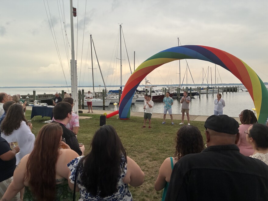 People standing near a dock with a pride display