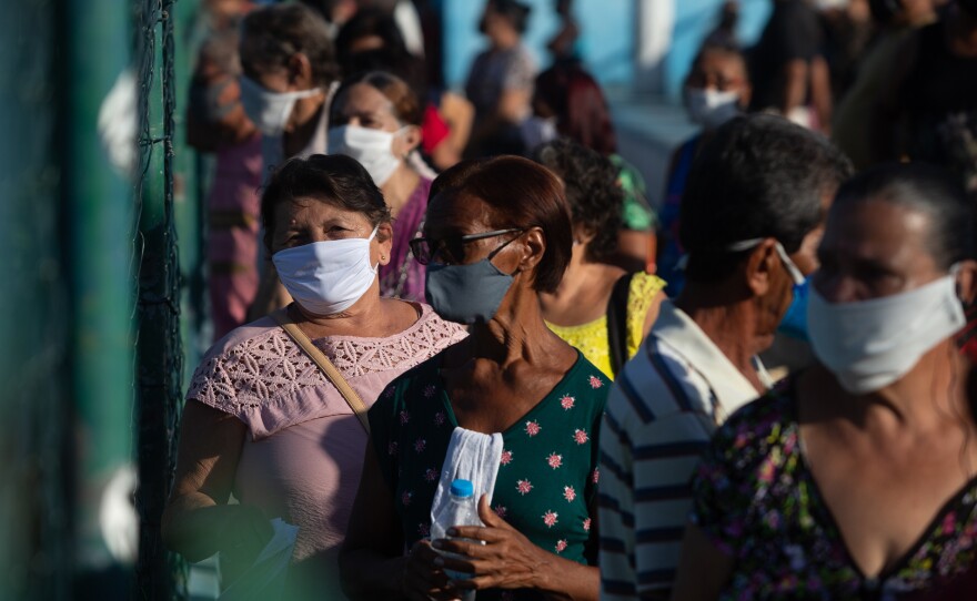 People line up for COVID-19 vaccinations Monday in Duque de Caxias, Brazil. After declaring he would never have the injection, Brazil's president now touts his health ministry's vaccination efforts. But experts say it may be too late.