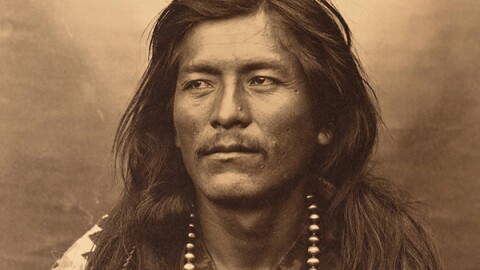 Photo of male Native American with text: "The Sons of Gunshooter A Navajo Resistance Story Dorothy Denetclaw and Matt Fizsimons"