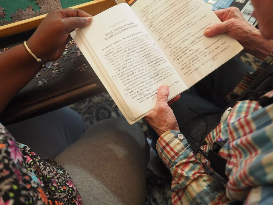 R. y A.J. sostienen un libro en francés.