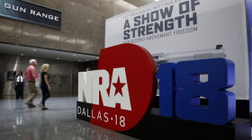 People walk by NRA convention signage in the Kay Bailey Hutchison Convention Center in Dallas, Thursday, May 3, 2018. The convention is scheduled to go through Sunday. (Sue Ogrocki/AP)