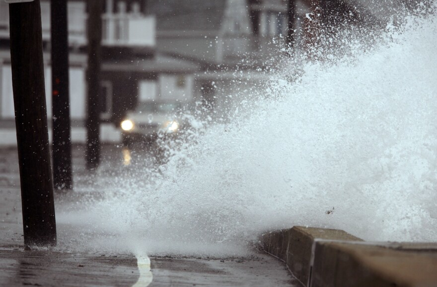 Waves pound the coast along Wells Beach, breaking over the seawall as a car passes by during a severe storm in Wells, Maine, on Tuesday, March 30, 2010. The slow-moving storm churned across the state Tuesday, prompting the National Weather Service to issue flood warnings. Beach erosion and minor coastal flooding along the southern coast was brought on by an extreme high tide and storm surge.