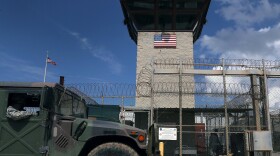 A Humvee passes the guard tower at the entrance of the U.S. prison at Guantanamo Bay in October 2016.