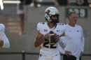 Colorado quarterback Dominiq Ponder, in a white jersey and helmet, holds a football