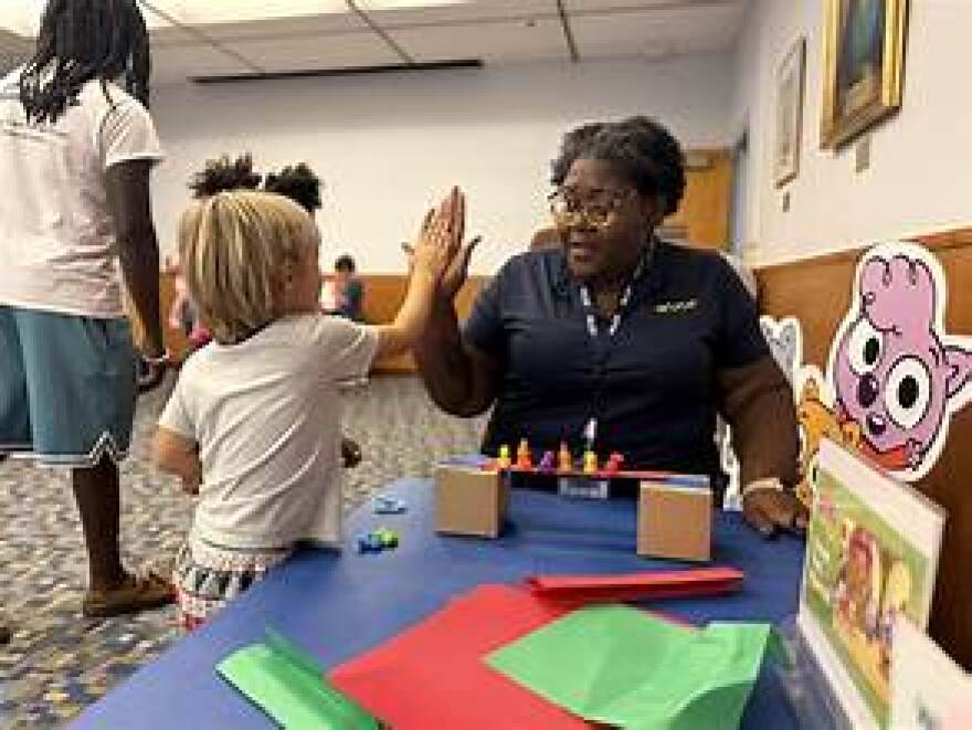 WUCF education staff works with a child at a hands-on learning station during an “On My Way to K” event last summer.