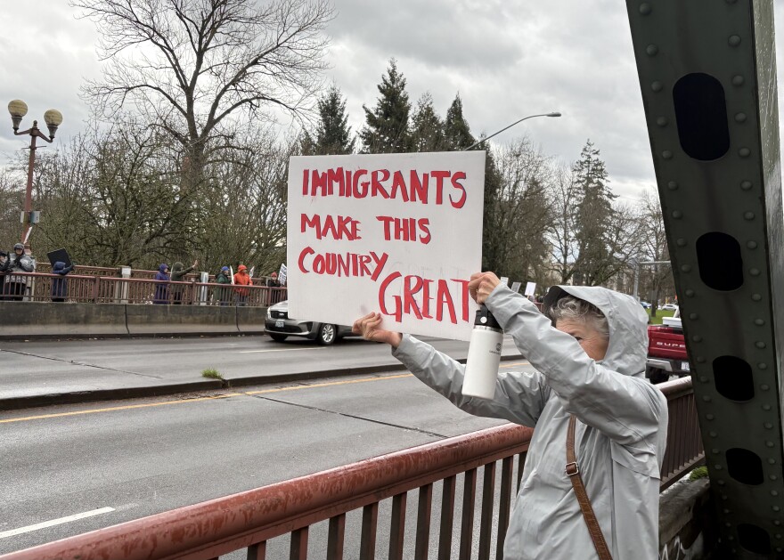 A woman holds up a sign during the first Day Without An Immigrant event on Dec. 18, 2025.
