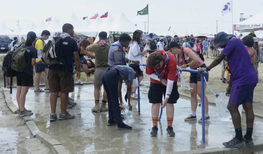 Attendees of the World Scout Jamboree cool off with water at a scout camping site in Buan, South Korea, on Friday.