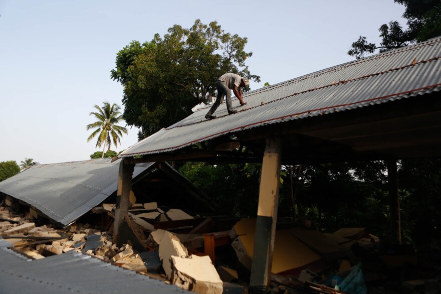 A man is seen working to salvage nails from the Mission Evangélique Baptiste du Sud d'Haiti Picot, which was destroyed in the 7.2 magnitude earthquake.