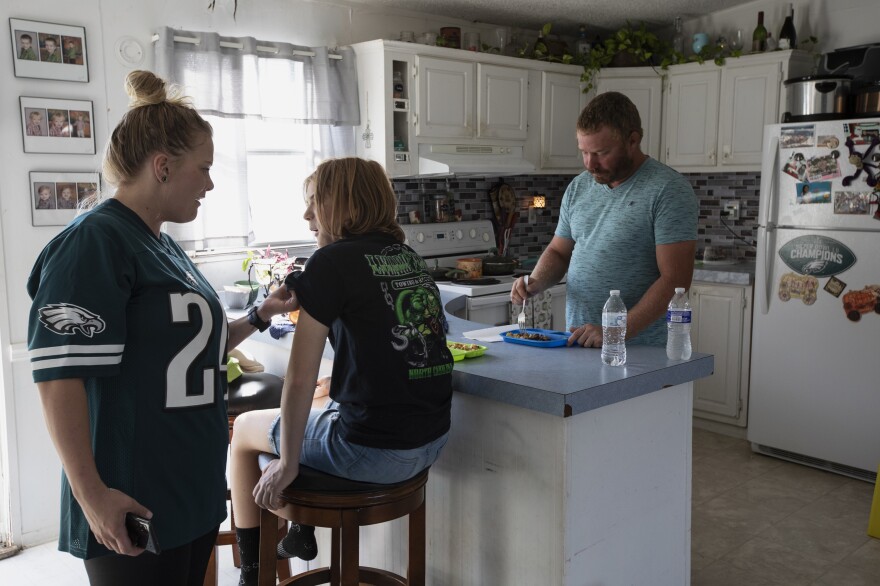 Jeremy Johnson says he would have paid the bill for his sons' foster care — had he been told he owed it. He already paid, steadily, the child support for his daughter Jalyn, 14 (center).