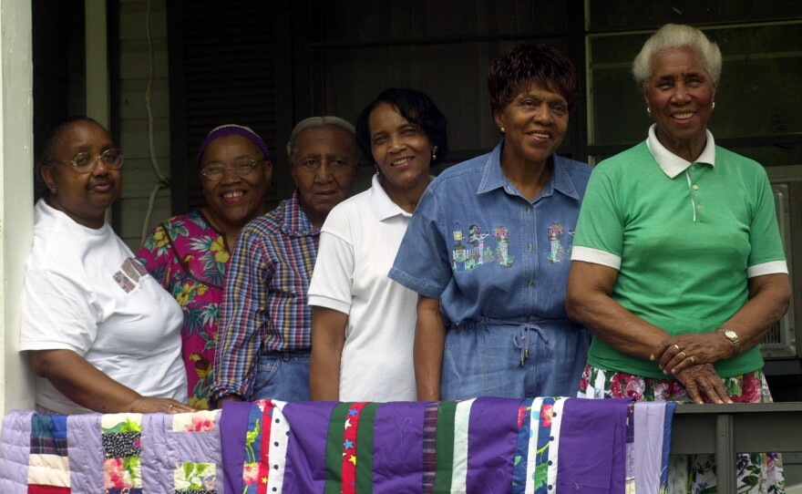 Arlonzia Pettway, right, poses with her relatives as they pose with their quilts on the porch of her Gees Bend, Ala., home., Thursday, May 15, 2003. Pettway quilts with a group of Gees Bend women who recently had a show at the Witney Museum in New York. From left: Nancy Pettway, Queenie Pettway, Allie Pettway, Lola Pettway, Lucy Marie Mingo and Arlonzia Pettway. (AP Photo/Jamie Martin)