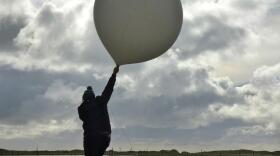 William Wells raises a weather balloon for launch on St. Paul Island, Alaska. 