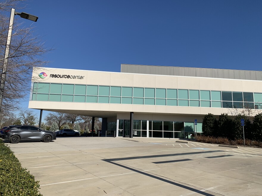 The exterior of a grey building against a blue sky. The words "resource center" are on the front of the building.