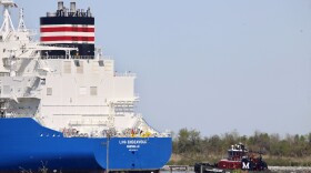 File - A tugboat helps guide a French ship, the LNG Endeavor, near Hackberry, La., on March 31, 2022. The ship was on its way to the Cameron LNG export facility to pick up liquified natural gas.  ]