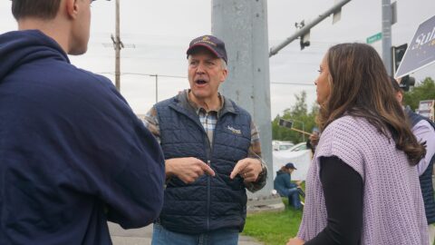 Sen. Dan Sullivan, R-Alaska, talks to staffers on the morning of Aug. 18, 2026, at the intersection of the Seward Highway and Northern Lights Boulevard. The Midtown Anchorage intersection is a favored spot for candidate sign-waving, and Sullivan, who is running for re-election, was there with U.S. Rep. Nick Begich, R-Alaska, also running for re-election.