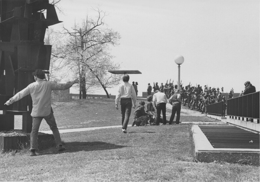 An injured student on the ground with Ohio National Guard nearby