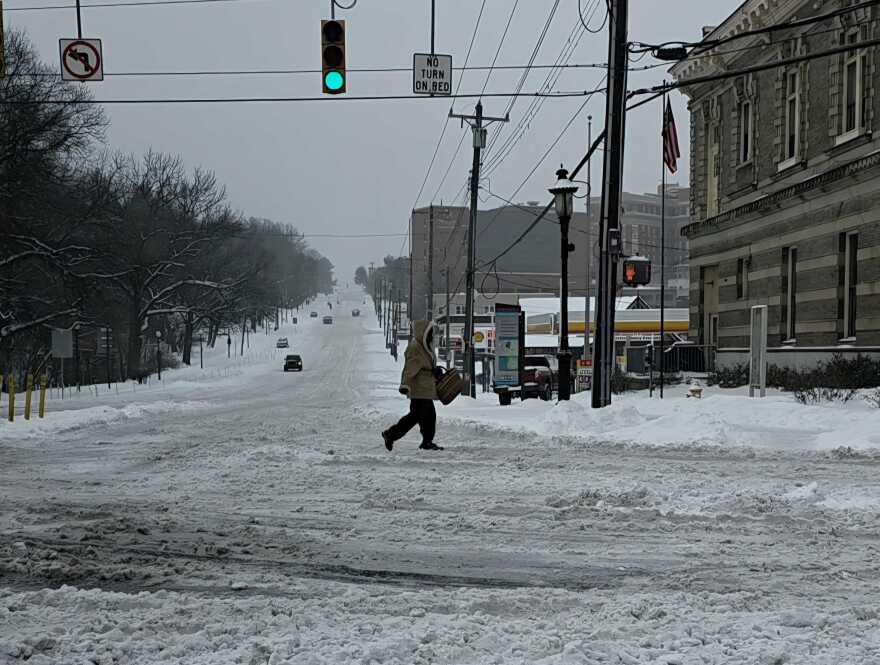 person crosses a snow-covered street