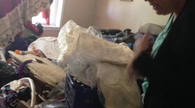 Haughton resident Susan Ouellette digs through the rubble in her bedroom. She found her wedding dress untouched by flood waters.