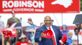 North Carolina Lt. Governor Mark Robinson tosses caps to supporters following a rally announcing he is officially running for Governor during a rally outside Ace Speedway in Elon, N.C. Saturday, April 22, 2023. (Photo courtesy of Lynn Hey for WUNC)