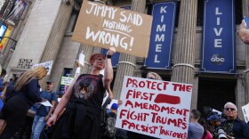Demonstrators hold signs outside El Capitan Entertainment Centre, where the late-night show "Jimmy Kimmel Live!" is staged, Thursday, Sept. 18, 2025, in Los Angeles. (AP Photo/Damian Dovarganes)