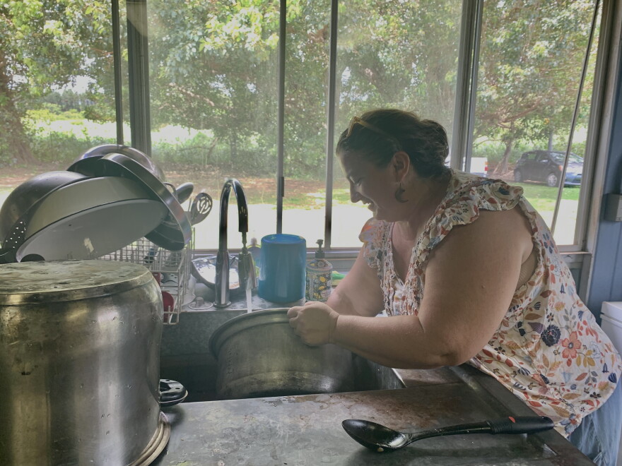 Nāʻālehu Resilience Hub co-lead Jessica Baker washes rice for the day's free community meal. The hub is working to turn their facility into a commercial kitchen that's open for community use.