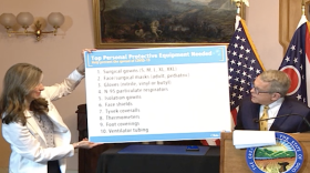 Gov. Mike DeWine and Dr. Amy Acton holds up a list of the items Ohio needs most.