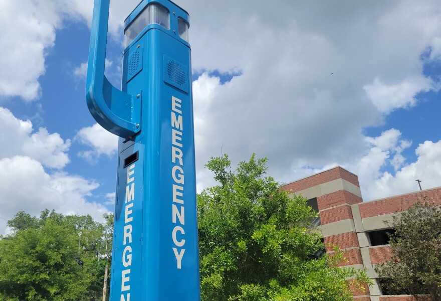 A University of Florida emergency call box stands outside a campus parking garage.