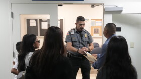  An officer listens to a question as he directs people to a courtroom, Wednesday, Jan. 10, 2024, in an immigration court in Miami. Immigration courts are buckling under an unprecedented 3 million pending cases, most of them newly arrived asylum-seekers. The number of migrants trying to fight their deportation in front of a US judge has grown by 50% in less than a year. 