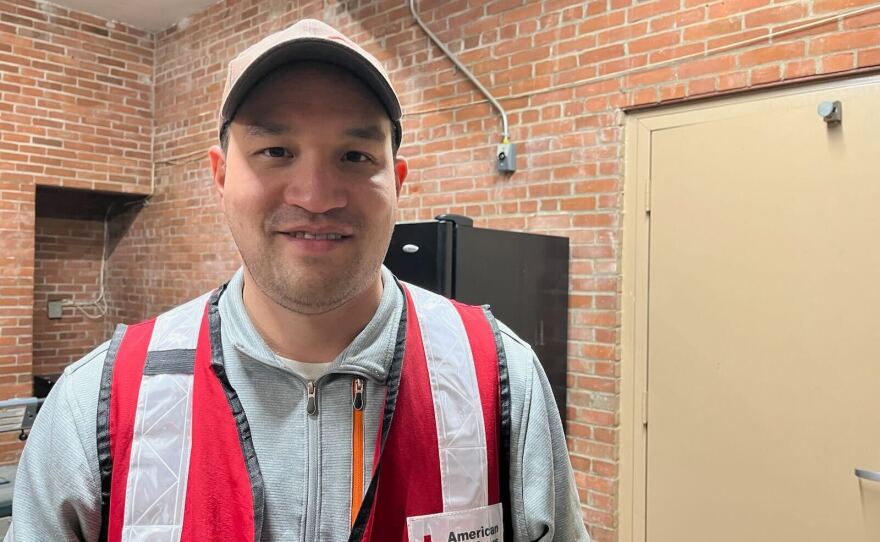 Man in red vest and hat.
