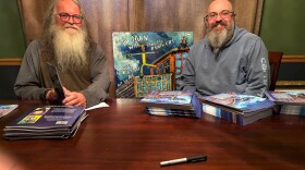 Author Rob Snow and son, Adrian Guenther (aka ARG the ARTisT) on book signing detail, with original cover painting in the background