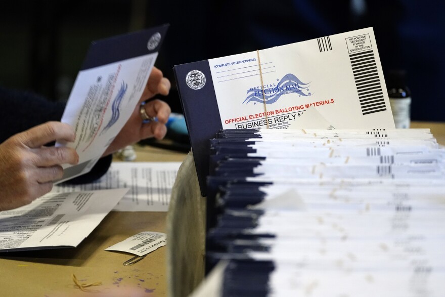 Election workers process mail-in and absentee ballots