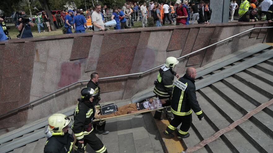 Firefighters carry an injured man out from a subway station after a rush-hour subway train derailment in Moscow on Tuesday.