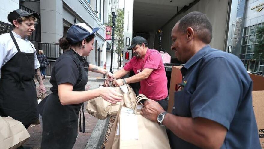 A Feeding Northeast FLorida team is pictured distributing meals in front of Bellwether in Downtown Jacksonville.