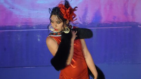 A model poses on the catwalk at the Far North Fashion Show, held April 15, 2026, at the Anchorage Museum. The dress she is wearing features red handprints on the collar, symbols of missing and murdered Indigenous people.