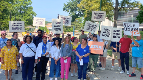 Supporters hold signs at a press conference and rally on UMKC's campus calling for higher wages for university workers.