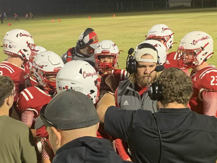 Campbell High School head coach Preston Compton confers with his staff and players during an Oct. 19 game against Savoy High School at Indian Field.