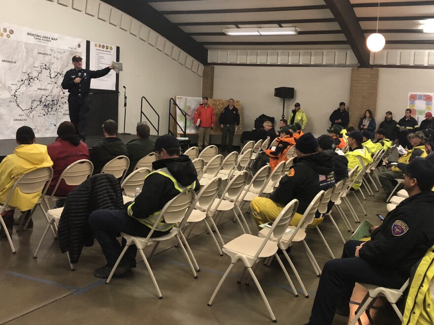 Emergency crews debrief ahead of Friday's fire search mission from the Camp Fire command post in Chico, Calif. Crews were warned about mud and debris slides along destroyed area.