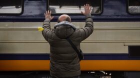 A Ukrainian militia waves goodbye to his family evacuating Kyiv by train to western cities in Kyiv, Ukraine.