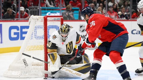 Washington Capitals center Nic Dowd (26) tries to get the puck past Vegas Golden Knights goaltender Akira Schmid (40) during the first period of an NHL hockey game, Friday, Feb. 27, 2026, in Washington. (AP Photo/Nick Wass)